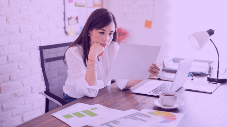A imagem mostra uma mulher analisando documentos para escrever os Jobs to be done da equipe de Produto.