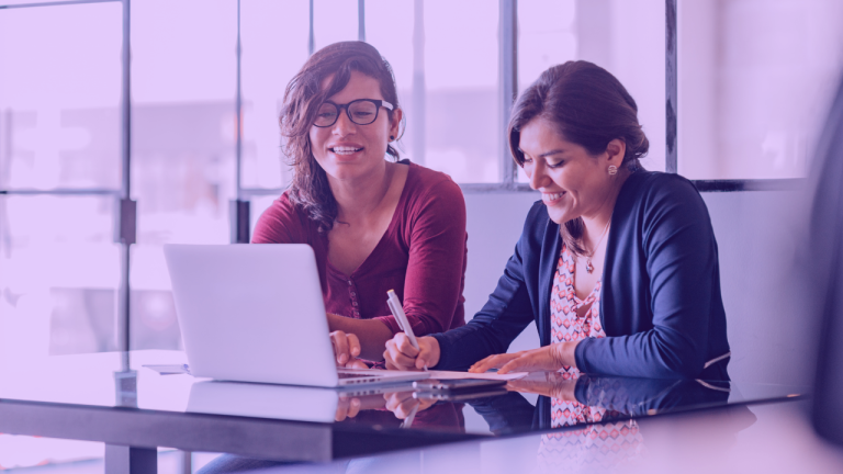 A foto mostra duas mulheres durante uma reunião. simbolizando o momento no qual o head de produto avalia um product manager n