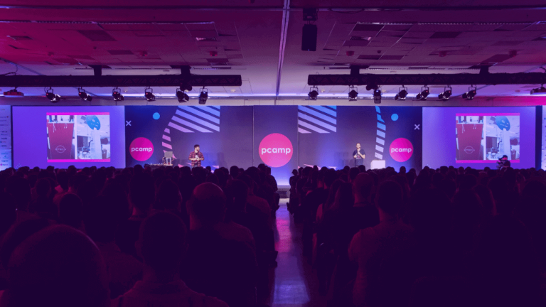 A imagem mostra o palco e a plateia do Product Camp em 2019, reforçando que o Product Camp 2022 vai retomar os encontros pres