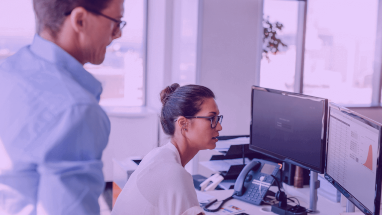 A imagem mostra uma mulher e um homem olhando para um computador, analisando dados do produto por meio de um gráfico.