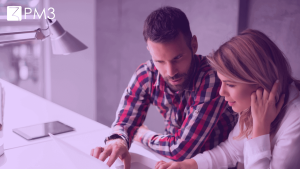A imagem mostra um homem e uma mulher trabalhando juntos no computador, ilustrando que, apesar da diferença entre Product Manager e Product Marketing Manager, o trabalho em equipe é essencial.