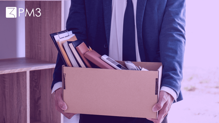 A imagem mostra um homem de terno segurando uma caixa de papelão com seus pertences, ilustrando a relação entre layoffs e áre