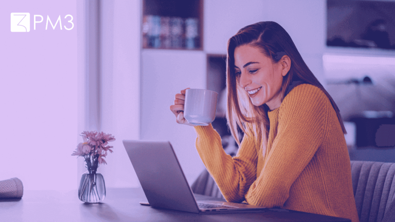 A imagem mostra duas mulheres sorrindo uma para a outra, sentadas de frente para seus respectivos computadores. A foto sugere